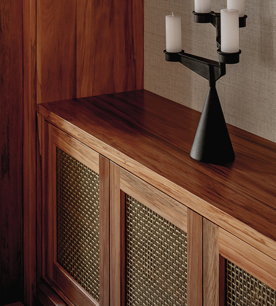 White cabinet front frames inset with best woven metal decorative grilles in basketweave pattern with mesh backing.