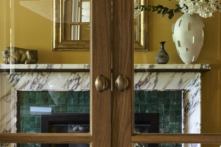 Double glass and timber doors lead into a yellow living room, with Joseph Giles hammered oval doorknobs.