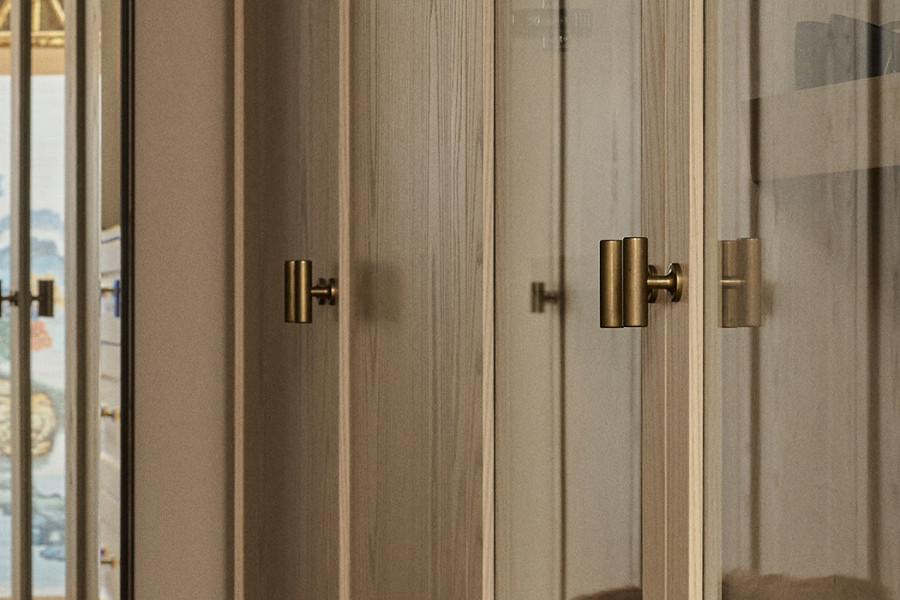 A walk in wardrobe with Armac Martin brass t-bars from In Residence.