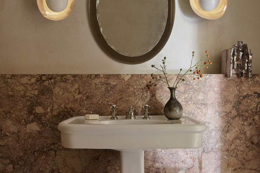 A powder room with bold pink marble wall with pedestal sink from In Residence and Polished Nickel heritage Perrin & Rowe separate hot and cold taps.