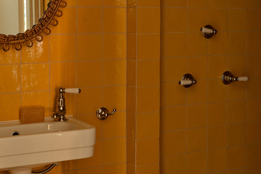A WC with golden grid tiles with powder-room sink from In Residence and Polished Nickel heritage Perrin & Rowe separate hot and cold taps.