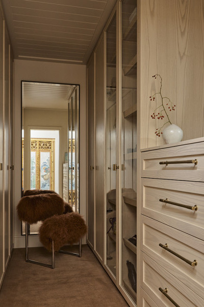 A walk in wardrobe with Armac Martin brass cabinet pulls from In Residence.
