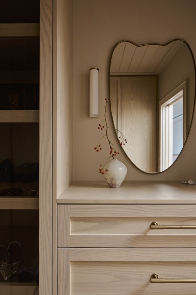 An ensuite master wardrobe with Armac Martin brass cabinetry hardware from In Residence.