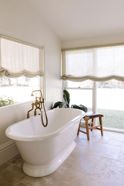 In the bathroom, polished brass Perrin & Rowe tapware and matching accessories bring cohesion and elegance, paired with Victoria & Albert freestanding baths and basins for a refined, luxurious feel. 