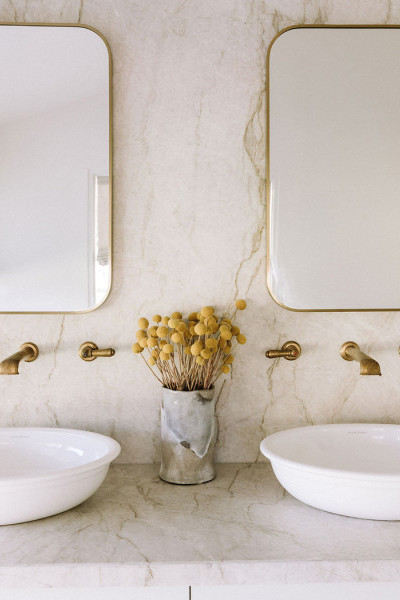In the bathroom, polished brass Perrin & Rowe tapware and matching accessories bring cohesion and elegance, paired with Victoria & Albert freestanding baths and basins for a refined, luxurious feel. 