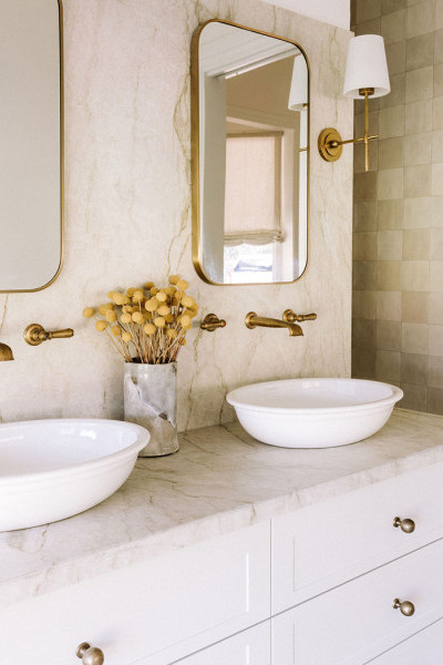 In the bathroom, polished brass Perrin & Rowe tapware and matching accessories bring cohesion and elegance, paired with Victoria & Albert freestanding baths and basins for a refined, luxurious feel. 