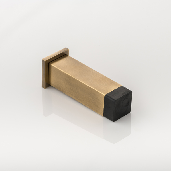 Cube II solid brass wall-mounted door stopper with decorative stepped plate